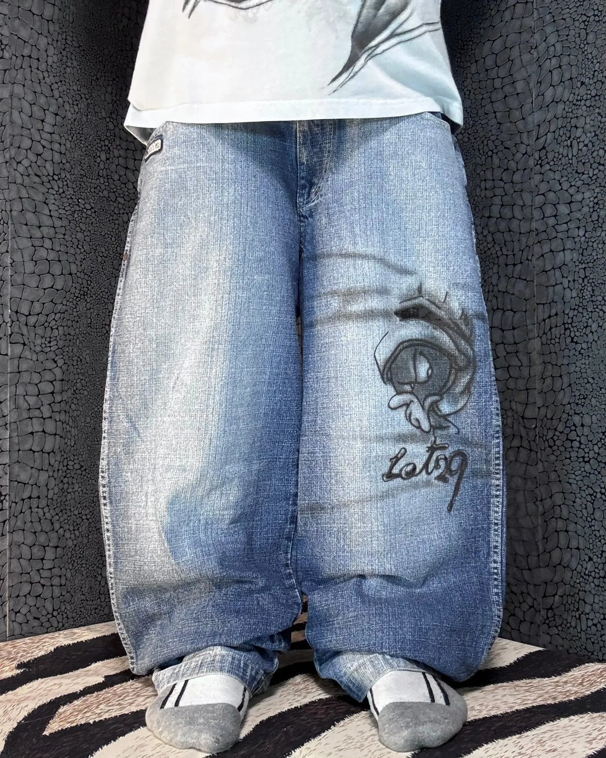 Lot29 baggy jeans, blue with a light wash – grey airbrush alien face and Lot29 script on the right thigh – front view, worn – vintage Y2K, size W32 / M, ships from Germany / Versand aus Deutschland
