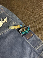 Fubu denim shorts, mid blue wash – close-up of the cream Fubu script on the back pocket – detail shot – vintage Y2K, size W28 / XS, ships from Germany / Versand aus Deutschland