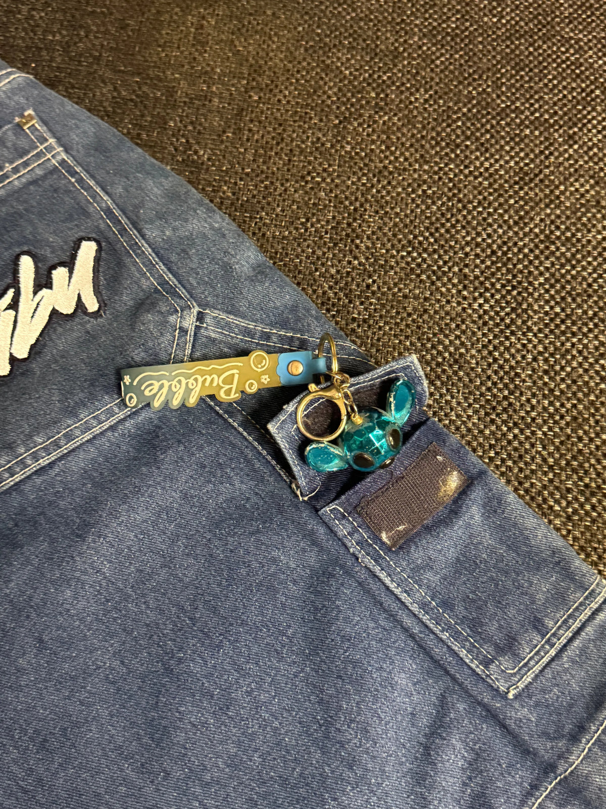 Fubu denim shorts, mid blue wash – close-up of the cream Fubu script on the back pocket – detail shot – vintage Y2K, size W28 / XS, ships from Germany / Versand aus Deutschland