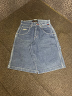 Fubu denim shorts, mid blue wash – small cream Fubu script on the front pocket, carpenter loop on the leg – flat lay, front – vintage Y2K, size W28 / XS, ships from Germany / Versand aus Deutschland