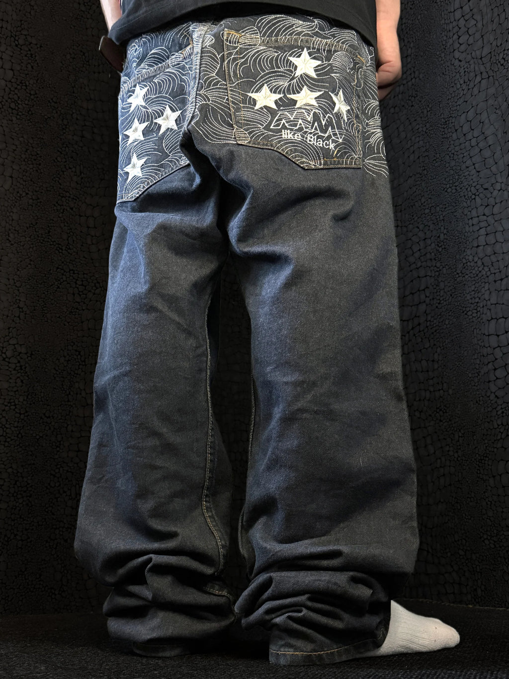 MM like black baggy jeans, dark indigo denim – tonal wave pattern with white stars across the yoke and back pockets – side view, worn – vintage Y2K, size W32 / M, ships from Germany / Versand aus Deutschland